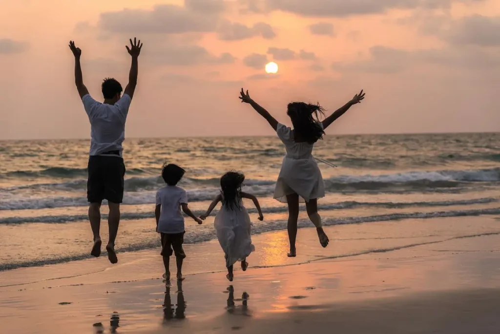 Roaming Crew family enjoying sunset on the beach in Asia with kids.