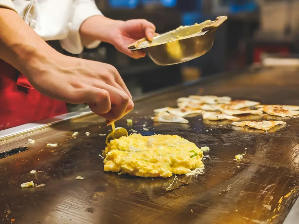 Okonomiyaki is Osaka’s soul food, Cooked fresh on a hotplate in front of you,
