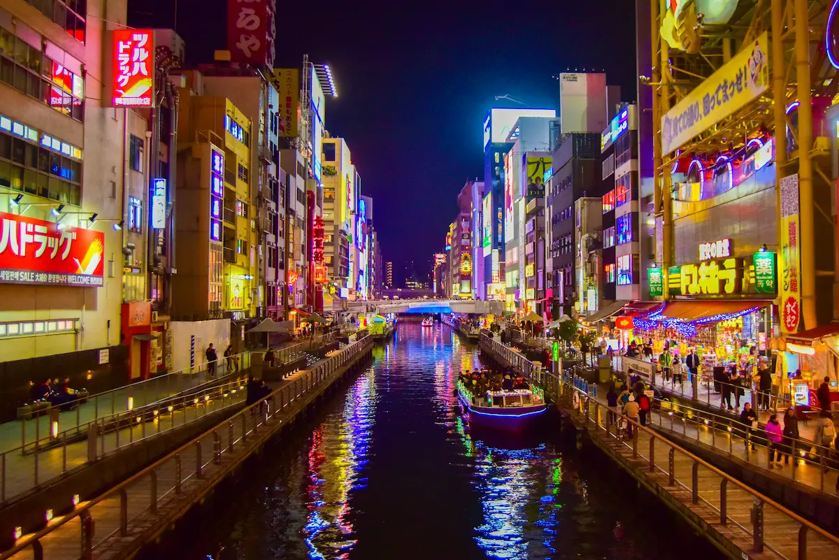 Kids enjoying neon lights in Dotonbori, Osaka.