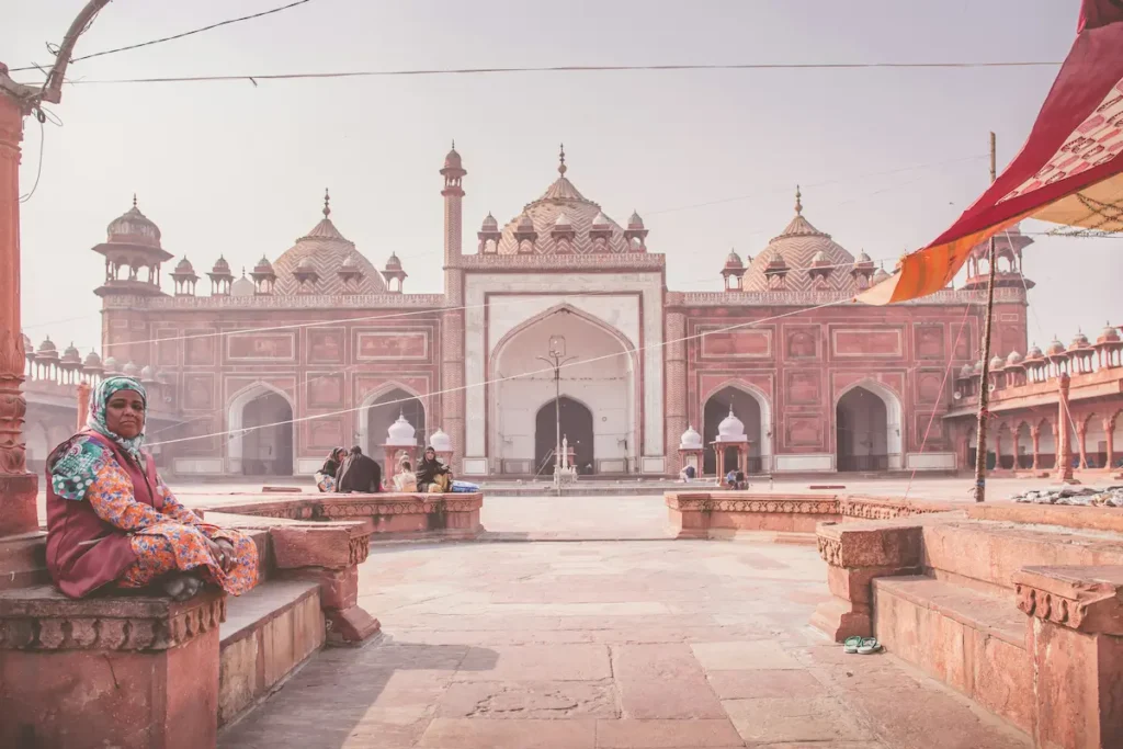 women sitting in front of Agra mashjid