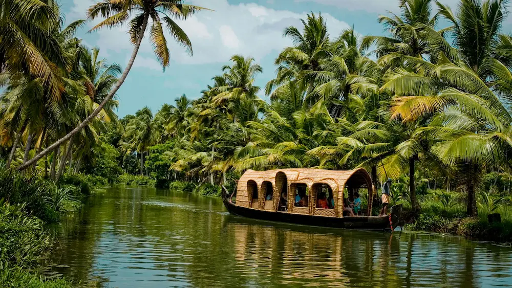 Traditional Kerala houseboat cruising through Alleppey backwaters.