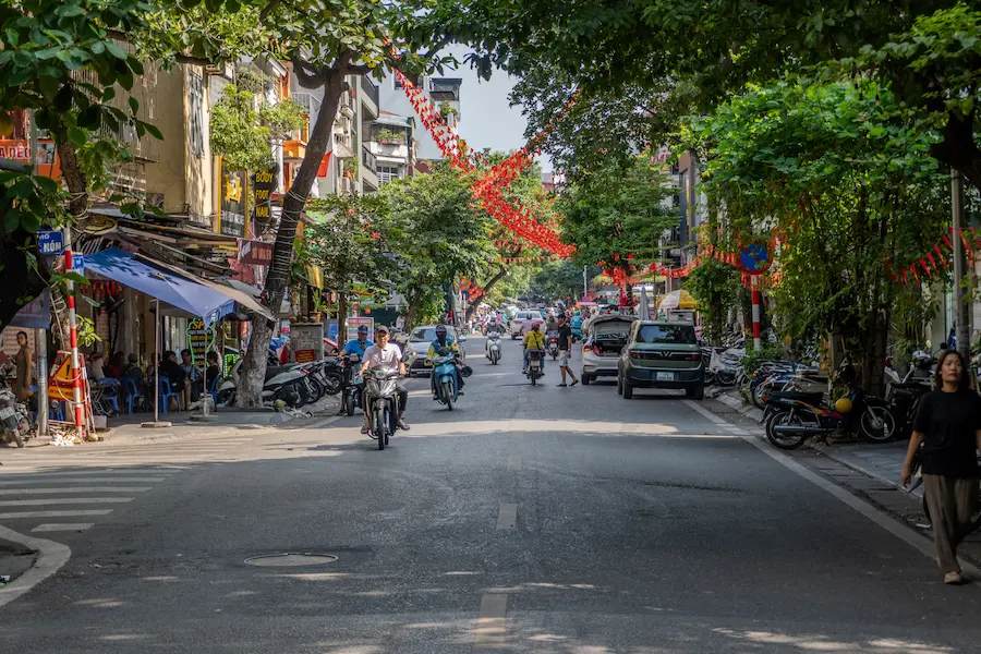 Family crossing a street safely in Hanoi with kids during a Vietnam family vacation