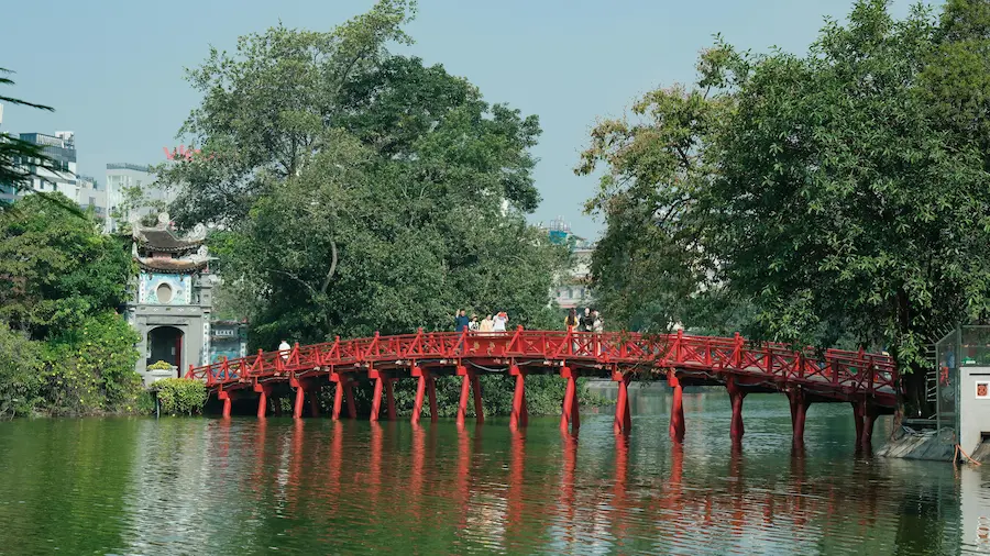 family crossing the red bridge on Hoàn Kiếm Lake