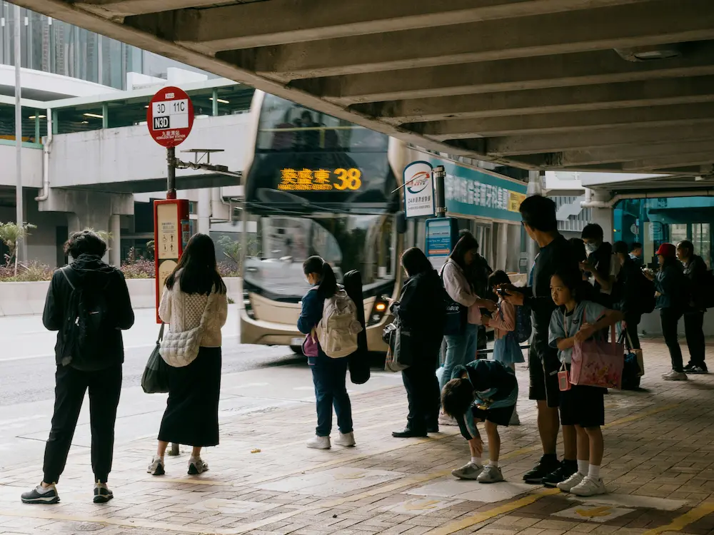 The family waiting at the bus stop shows planning Japan with kids is quite thoughtful.