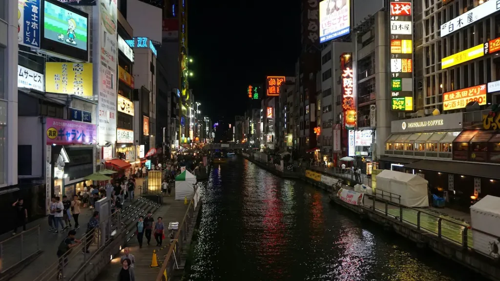 parents and child exploring a lively Osaka street at night.