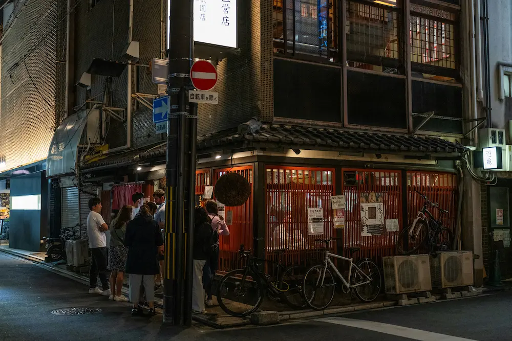 parents with kids standing outside a ramen noodle bar in Kyoto