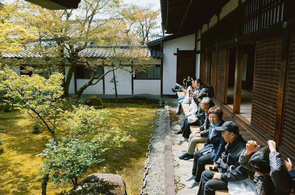 people sitting inside a Japanese temple without shoes.