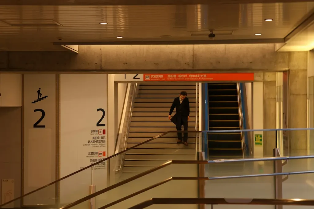 Parents navigating a Japanese train station with a stroller.