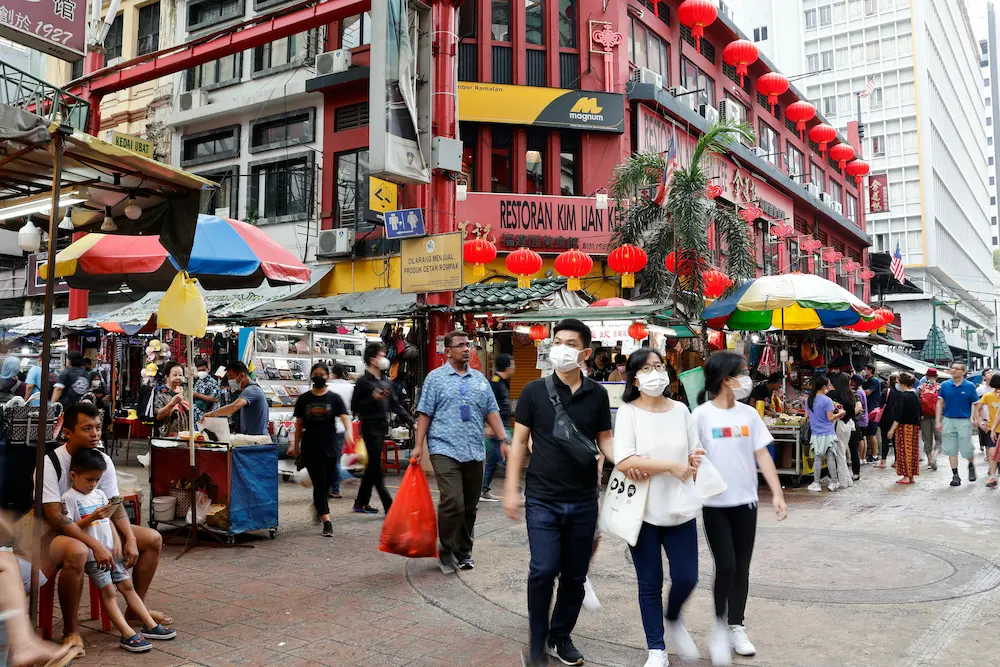 A child observing a pedestrian crossing in a crowded Chinese street calmly