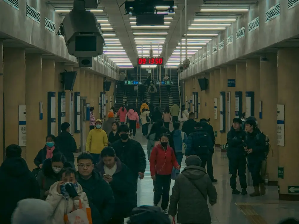 Beijing metro busy station family crossing with mobile payment scan. 
