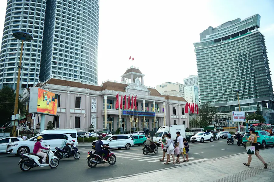 Family exploring Ho Chi Minh City with kids near busy scooter-filled streets