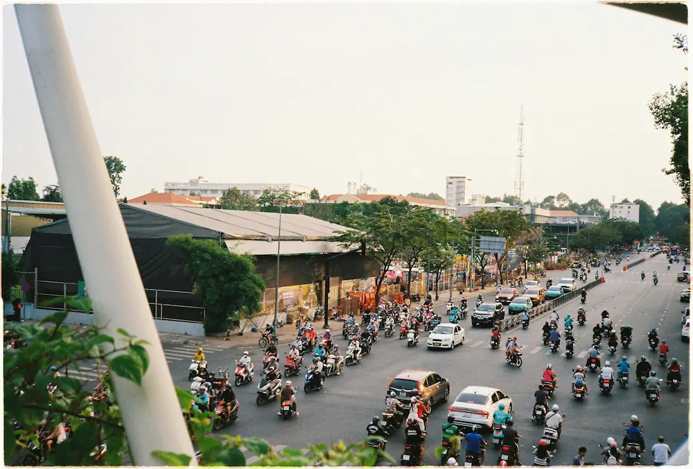 Parents crossing a busy road in Ho Chi Minh City with young children
