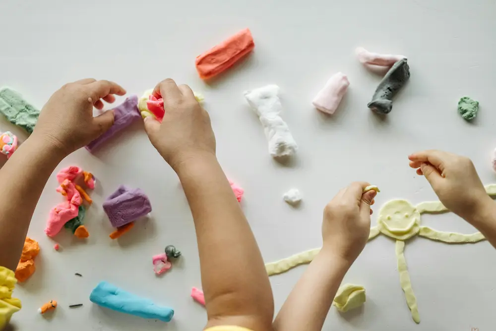 Kids playing with slime or clay in airplane seats.