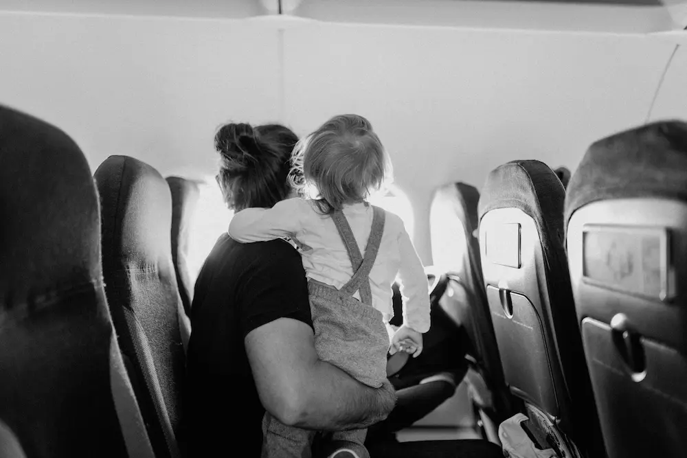 Mum calming kid on her long-haul flight to Asia with kids. 
