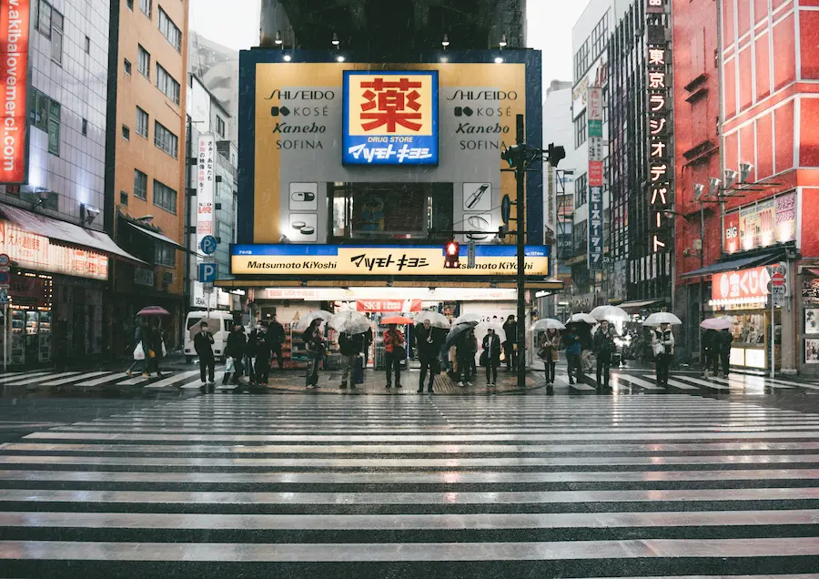 Family walking in Japan during rainy season with umbrella