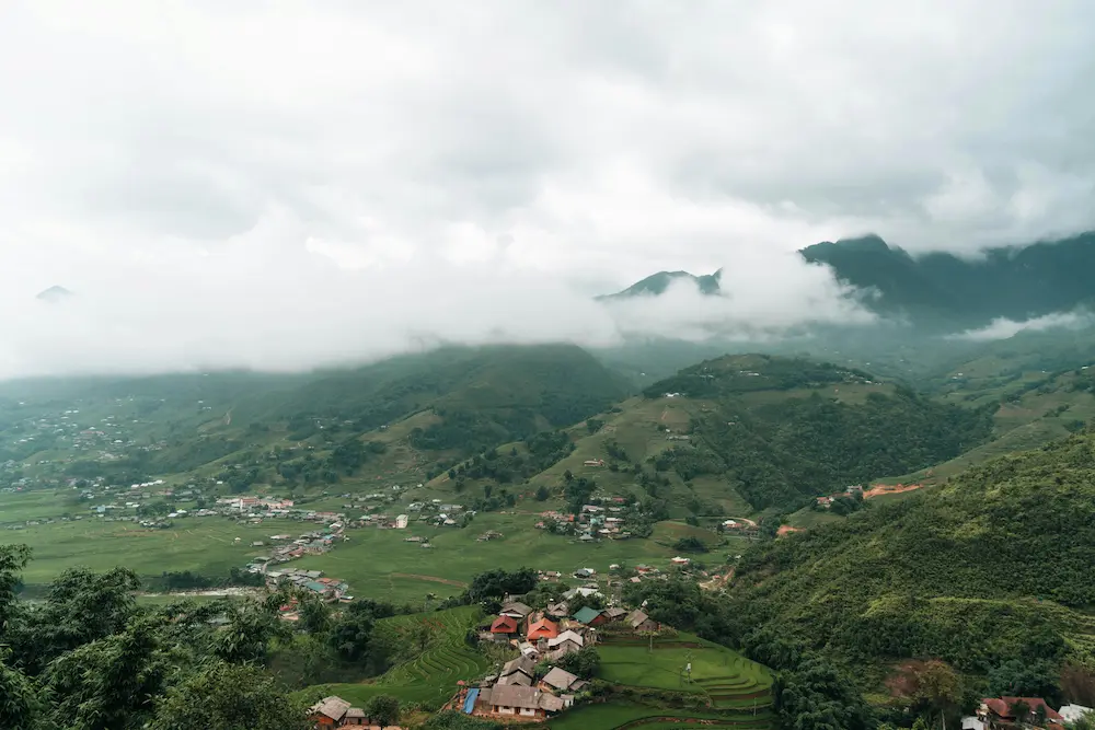 Misty mountain views of Sapa rice terraces from a family eco-lodge balcony.