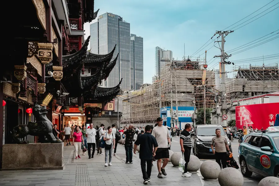 Crowded narrow streets near Yu Garden Shanghai with parents carrying a toddler
