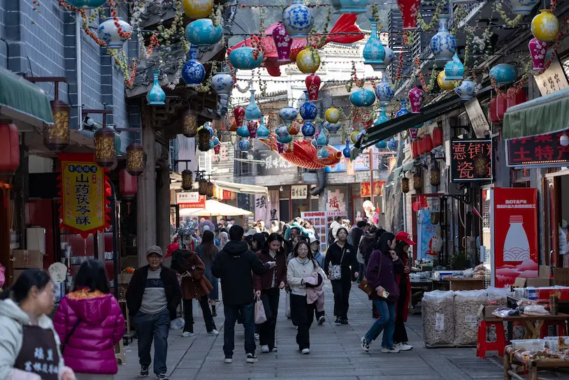 Crowded narrow streets near Yu Garden Shanghai with parents carrying a toddler