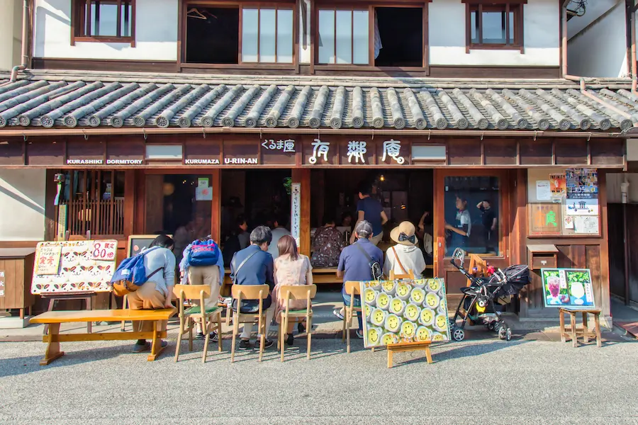 family relaxing on a street cafe paved pedestrian pathway on an Osaka day trip with kids.
