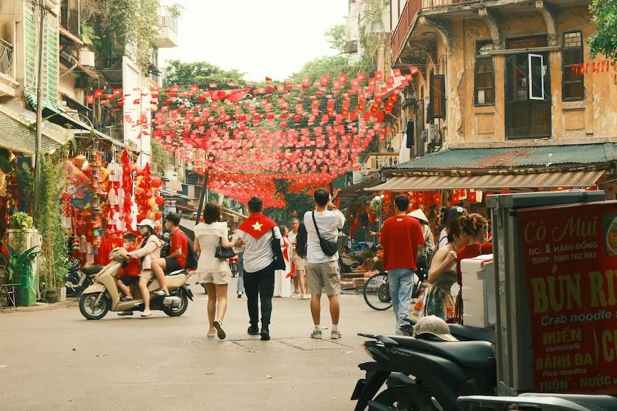 A family exploring a side street in Hanoi's Old Quarter.
