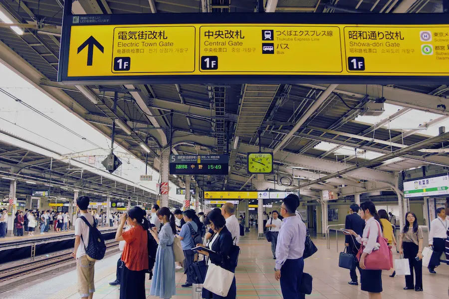 Parents navigating Osaka train station with stroller and kids in Japan