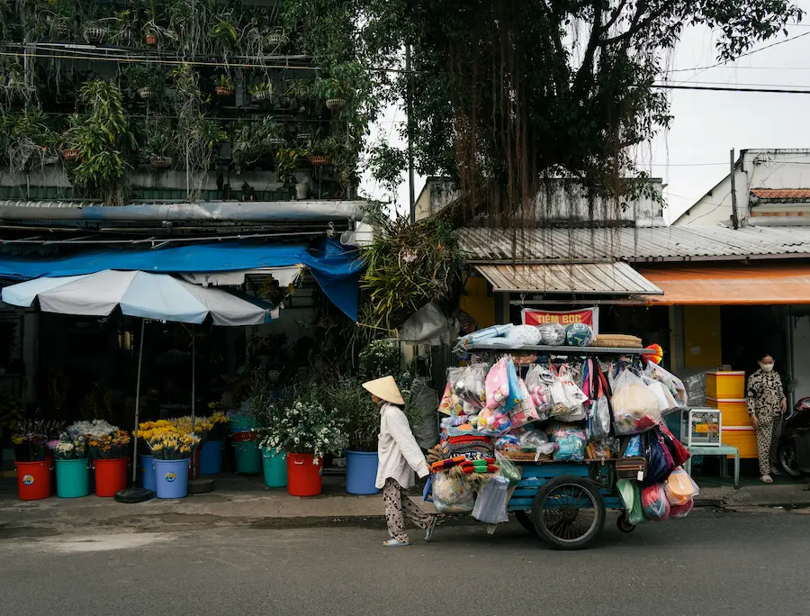 Mom is trying to walk with a stroller on the busy road in the Phu Quoc local market area.