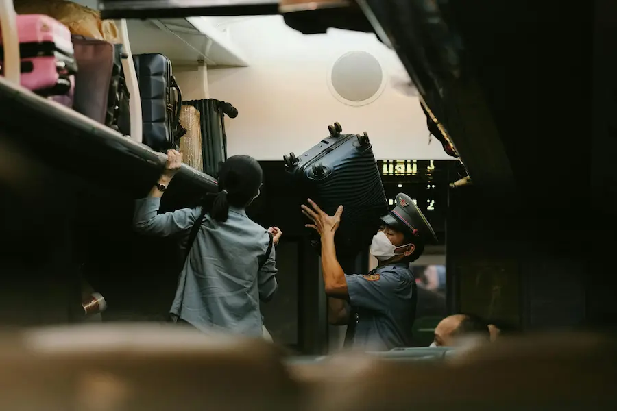Train attendant helping parents to store Large luggage storage racks between train carriages in China