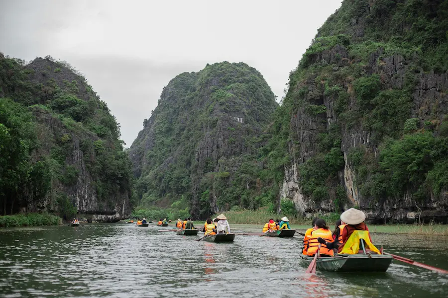 Family of four on a traditional rowboat tour in Ninh Binh, Vietnam.