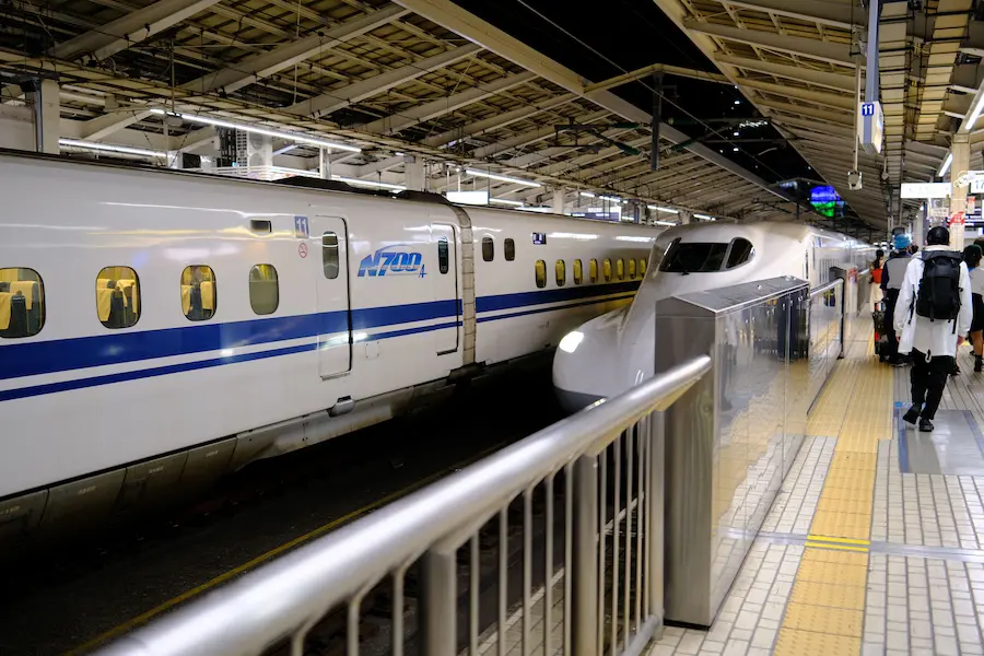 Family boarding a Shinkansen train in Japan with children and luggage