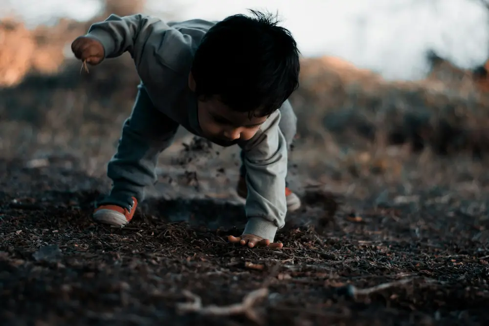 Toddler exploring Bali's black volcanic landscape
