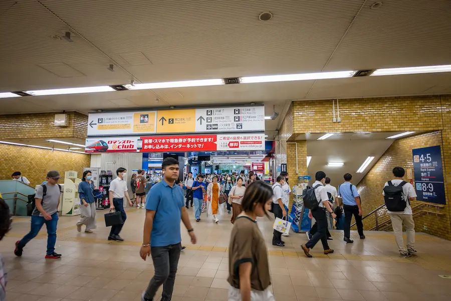 Family navigating a busy Japanese train station with kids.